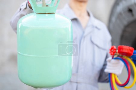 Photo for Car Air Conditioning Repair, Repairman holds bucket refrigerant and monitor tool to check and fix car air conditioner system, Technician checks car air conditioning system refrigerant recharge - Royalty Free Image