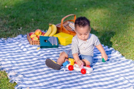 Photo for Little kid boy play toys in the garden, Child boy playing with little wooden toy cars outdoor - Royalty Free Image