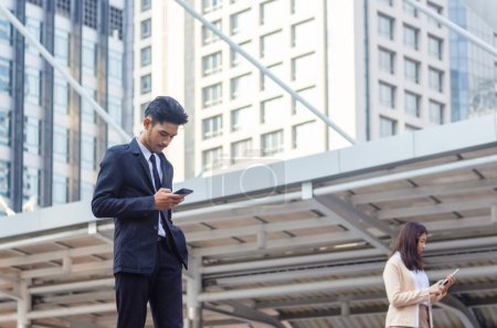 Téléchargez les photos : Homme utilisant un smartphone, Les gens d'affaires rencontrent et partagent des idées, Jeune équipe d'affaires asiatique discuter le matin - en image libre de droit