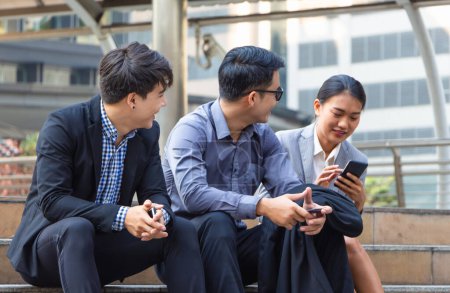 Téléchargez les photos : Jeunes gens d'affaires assis dans les escaliers avec des amis, Les gens d'affaires rencontrent et partagent des idées, Jeune équipe d'affaires asiatique discuter le matin - en image libre de droit