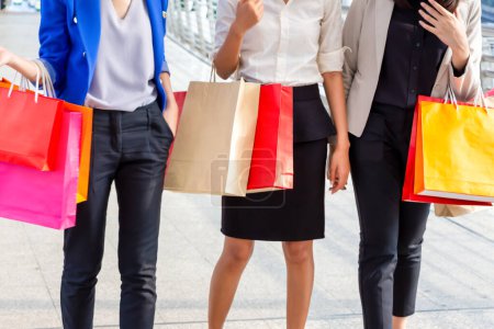 Photo for Group of young Asian women carrying shopping bags while walking along the street. Happy Life and Shopping Concept - Royalty Free Image