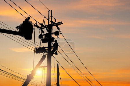 Photo for Silhouette of Electrician officer team climbs a pole and using a cable car to maintain a high voltage line system, Shadow of Electrician lineman repairman worker team at climbing work on the electric post power pole - Royalty Free Image