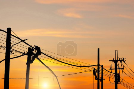 Photo for Silhouette of Electrician lineman worker at climbing work on the electric post power pole, Electrician checking lighting to the LED street lamp post - Royalty Free Image