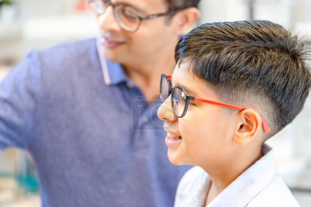 Photo for Indian-thai boy and father choosing glasses in optics store, Portrait of Mixed race ethnicity kid wearing glasses at the optical stor - Royalty Free Image