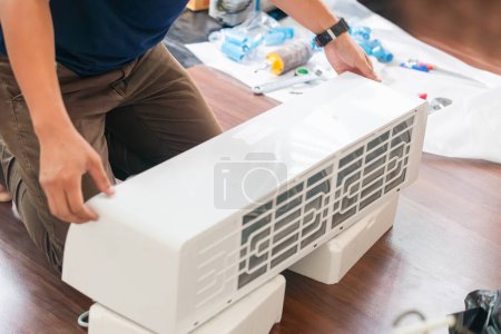 Téléchargez les photos : Technicien homme installer un nouveau climatiseur, Service de réparateur pour la réparation et l'entretien des climatiseurs - en image libre de droit