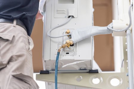 Foto de Técnico hombre instalar nuevo acondicionador de aire, servicio de reparador para la reparación y mantenimiento de aire acondicionado - Imagen libre de derechos