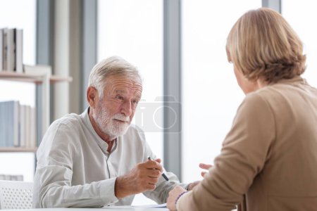 Photo for Senior man with a pen and document signing contract in doctor's office, senior patient making a health insurance deal - Royalty Free Image