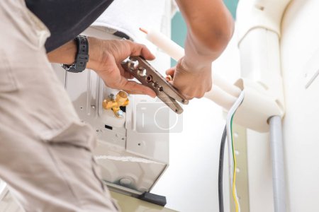 Téléchargez les photos : Technicien homme couper des joints avec l'outil de tuyau de cuivre pour fixer et installer un nouveau climatiseur - en image libre de droit