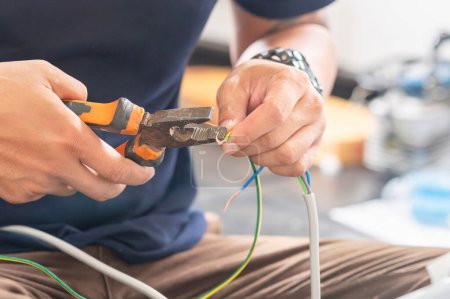 Téléchargez les photos : Technicien homme branchant des fils électriques avec des pinces pour installer la nouvelle climatisation, service de réparation, et installer un nouveau concept de climatiseur - en image libre de droit