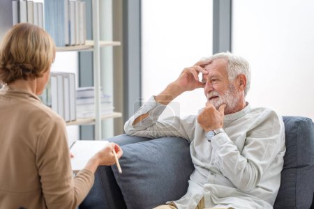 Foto de Hombre anciano consultando a una mujer mayor en el acogedor sofá en casa, Conceptos de atención médica de ancianos, Pareja mayor en la sala de estar - Imagen libre de derechos