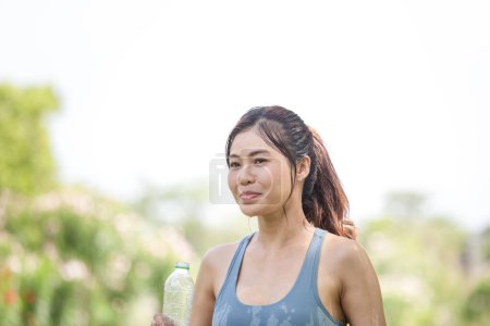 Foto de Asiática sportswoman se enfría por verter agua dulce, fitness femenino verter agua sobre su perfecto cuerpo - Imagen libre de derechos