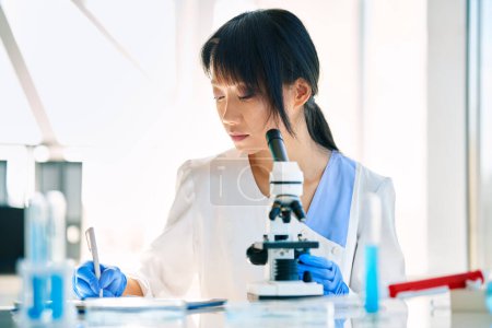 Photo for Scientist researcher working writing down analysis information at modern medical research laboratory. Medicine, biotechnology, microbiology concept - Royalty Free Image