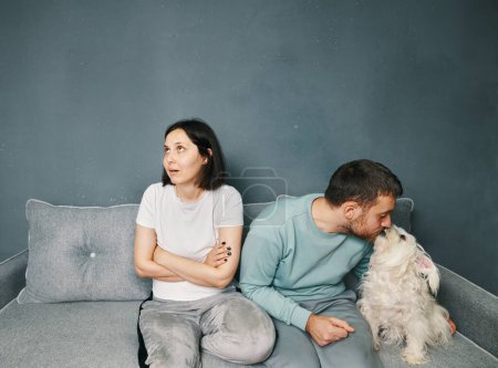 Foto de Jealousy in the family. Man cuddling his dog do not pay attention to his wife. Funny emotions. Resentment, love triangle - Imagen libre de derechos