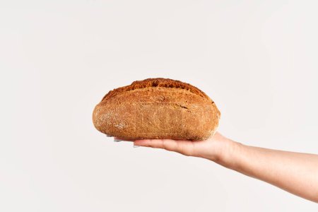 Homemade multigrain bread in woman hand over white background. Bakery, food concept