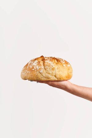 Homemade multigrain bread in woman hand over white background. Bakery, food concept