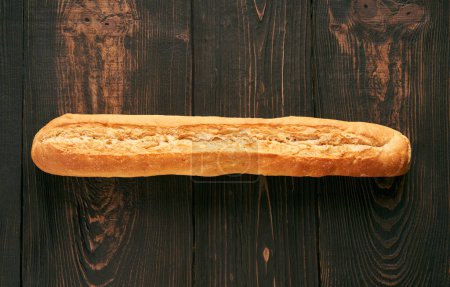 Fresh made baguette on wooden table background. Bakery, food concept