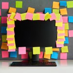 Computer monitor full of blank colorful sticky notes reminders. Workplace, plan concept