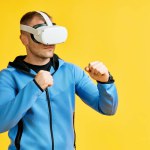 Man wearing virtual reality goggles doing shadow boxing over yellow background