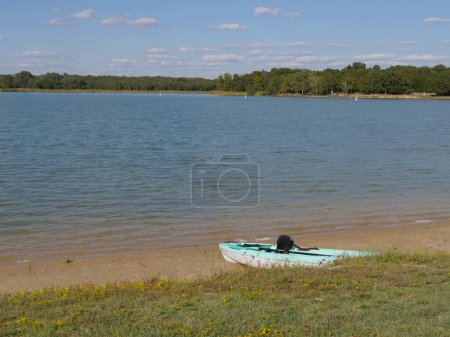 Téléchargez les photos : Green-white kayak boat shored beside a lake - en image libre de droit
