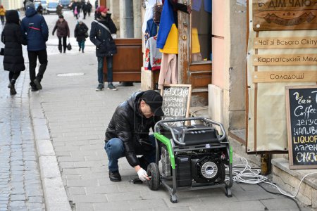 Téléchargez les photos : Lviv, Ukraine - 29 déc. 2022 : Un générateur d'électricité devant un magasin lors d'une panne d'électricité à la suite de frappes de missiles russes. - en image libre de droit