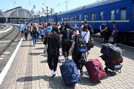 Photo for Lviv, Ukraine - May 25, 2022: Evacuees walk along a platform after arriving at the railway station in city of Lviv. - Royalty Free Image