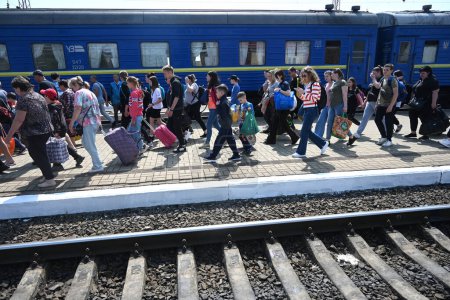 Photo for Lviv, Ukraine - May 25, 2022: Evacuees walk along a platform after arriving at the railway station in city of Lviv. - Royalty Free Image