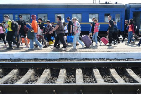Téléchargez les photos : Lviv, Ukraine - 25 mai 2022 : Les évacués marchent le long d'une plate-forme après leur arrivée à la gare de Lviv. - en image libre de droit