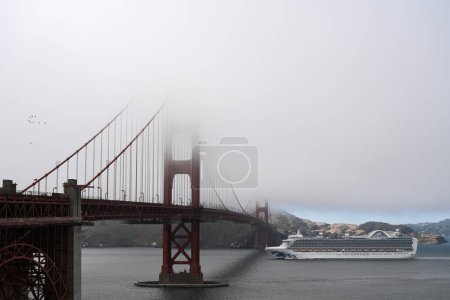 Téléchargez les photos : San Francisco, CA, USA - 26 juillet 2023 : Un bateau de croisière passe le Golden Gate Bridge dans un brouillard. - en image libre de droit