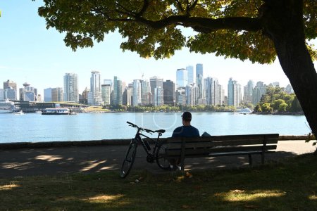 Photo for Vancouver, BC, Canada - August 16, 2023: A people on Stanley Park with downtown of the Vancouverat at the background. - Royalty Free Image