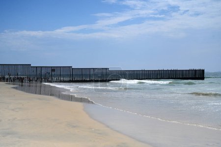 Photo for A fence on the United States - Mexico border where it meets the Pacific Ocean in Border Field State Park Beach - Royalty Free Image