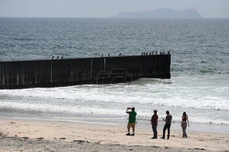 Photo for San Diego, CA, USA - July 30, 2023: Tourists near USA Mexico Border Wall in Border Field State Park Beach. - Royalty Free Image