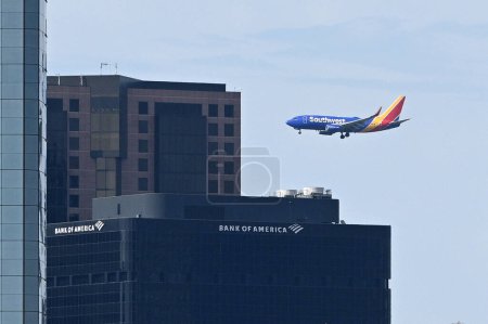 Foto de San Diego, CA, EE.UU. - 31 de julio de 2023: El avión de Southwest Airlines vuela por Bank of America en el centro de San Diego. - Imagen libre de derechos