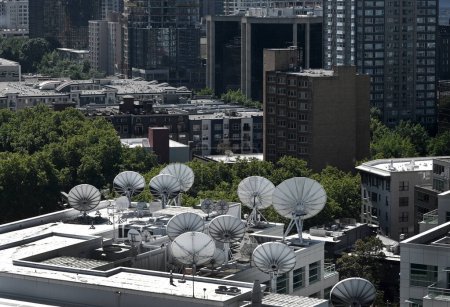 Photo for Satellite dishes, antenna dishes on the roofs of building. - Royalty Free Image