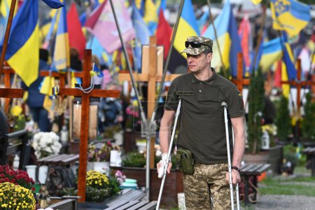 Foto de Lviv, Ucrania - 1 de octubre de 2023: El militar ucraniano visita las tumbas de los soldados ucranianos caídos en el cementerio militar de Lviv. - Imagen libre de derechos