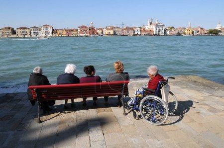 Photo for VENICE, ITALY - MAY 17, 2012: Venice inhabitants resting on the bench. - Royalty Free Image