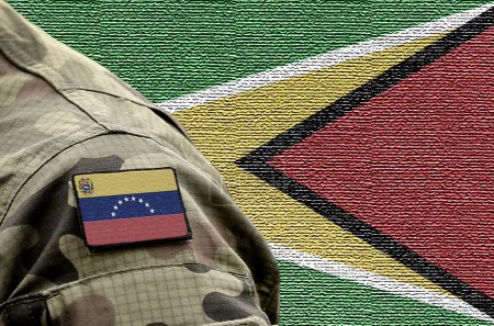 Téléchargez les photos : Drapeau du Venezuela sur uniforme militaire et drapeau de la Guyane en arrière-plan. Venezuela VS Guyana. - en image libre de droit