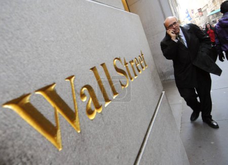 Foto de Nueva York, EE.UU. - NOV 07, 2011. Un hombre pasa por Wall Street signo de marca de la famosa calle financiera en Nueva York, Wall Street. - Imagen libre de derechos