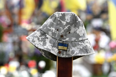 Sombrero de soldado sobre la tumba en el cementerio militar de soldados ucranianos muertos durante el combate con tropas rusas
