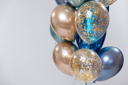 Photo for Blue and golden balloons on white background on the right. Copy space. - Royalty Free Image