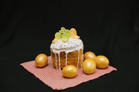Photo for Easter cake with white icing and colorful decorations and yellow eggs on black background. - Royalty Free Image