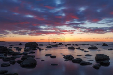 Foto de Vista tardía al atardecer rojo de la costa rocosa del mar, luz damática, larga exposición - Imagen libre de derechos