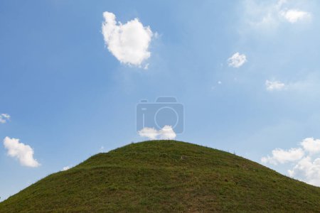 Ideal green round hill and blue sky with clouds above it. Krakus Mound, Krakow, Poland.