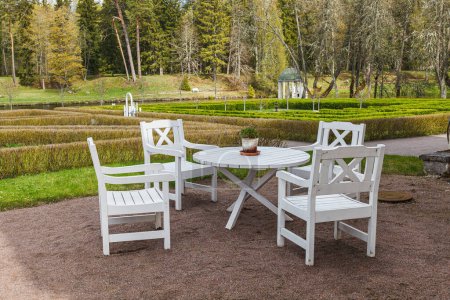 Foto de Mesa de jardín de madera blanca y sillas con parque en el fondo - Imagen libre de derechos