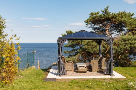 Lounge-Bereich für Erholung und Partys mit Stühlen und Tisch in einer privaten Residenz an der Ostseeküste. Holzmöbel Tisch und Stühle für die Meditation mit Blick auf das Meer und den Sonnenuntergang.