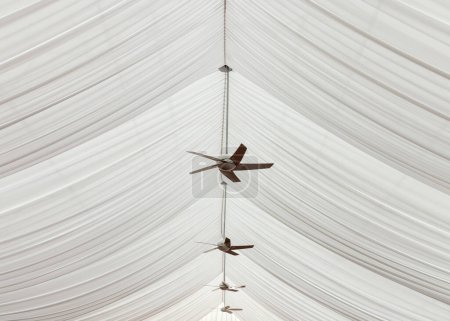 Foto de Fans mounted in side wavy white tent ceiling. - Imagen libre de derechos
