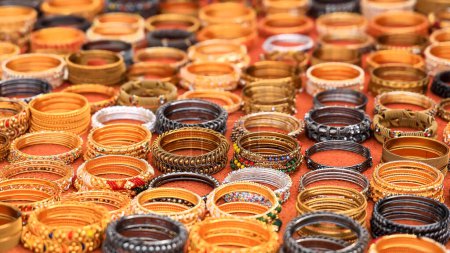 Téléchargez les photos : Several different bangles and bracelets are arranged for sale on the street side in India. Selective focus. - en image libre de droit