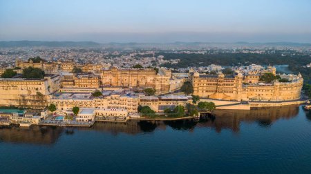 Photo for Udaipur, Rajasthan, India -October 16, 2022 :Aerial view city palace in Udaipur during sunrise, known for its beautiful lakes, palaces, and historical significance. The city was founded in 1559. - Royalty Free Image