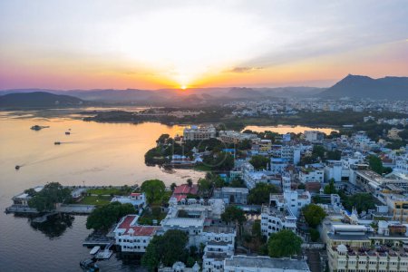 Photo for Udaipur, Rajasthan, India -October 16, 2022 :Aerial view of Udaipur city during sunset, known for its beautiful lakes, palaces, and historical significance. The city was founded in 1559. - Royalty Free Image