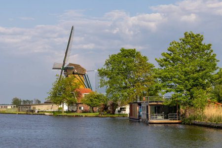 Photo for Historic windmill by the river called Zwanburgermolen near Warmond, Netherlands in spring time - Royalty Free Image