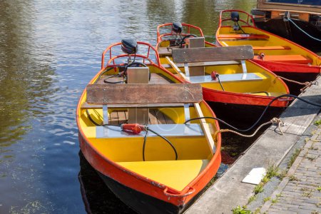 Foto de Pequeños barcos a motor de colores en los canales de la famosa aldea de Giethoorn, Países Bajos. - Imagen libre de derechos